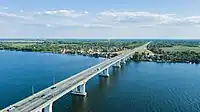 An aerial view of the Antonivka Road Bridge, with Dachi on the far bank