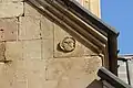 High-relief decoration of a face upon the upper portion of the western façade.