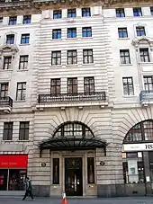 Exterior of block of luxury flats with brown plaques on either side of the entrance