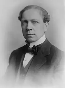 A posed, antique photograph of writer and cartoonist Art Young wearing formal attire of the early 20th century.