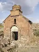 Artavazik Church of the 7th century with huge khachkar monument behind.