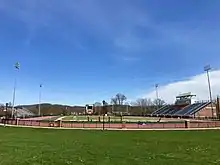 field in foreground and scoreboard in the background with stadium seating on each side