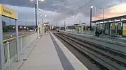 Ashton West tram station at twilight, in the direction of Ashton-under-Lyne in October 2016.