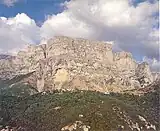 A small village on the top of a hill and huge cliffs on the background