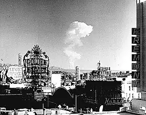 Image 24This view of downtown Las Vegas shows a mushroom cloud in the background. Scenes such as this were typical during the 1950s. From 1951 to 1962 the government conducted 100 atmospheric tests at the nearby Nevada Test Site. (from Nuclear weapon)