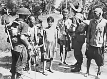 Image 88Australian soldiers and local civilians on Labuan Island. The soldier on the left is armed with an Australian-designed Owen gun. (from Military history of Australia during World War II)