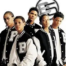 The cover consists of a white background occupied by five young men wearing black-and-white varsity jackets. The group's logo is behind them on the top-right corner, colored in black and grey.