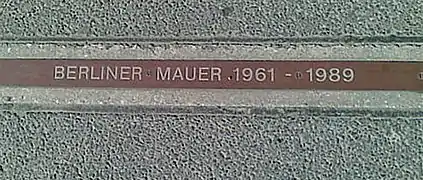 A "BERLINER MAUER 1961–1989" plaque near Checkpoint Charlie signifying where the Wall stood