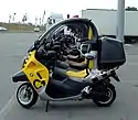  A picture from the side through the cockpit areas of several BMW C1 scooters which are parked side by side in perfect alignment