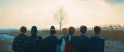 Seven members standing in front of tree