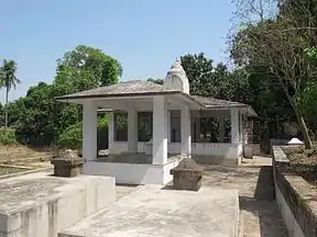 A gazebo-like stone structure pyramidal roof and a small dome