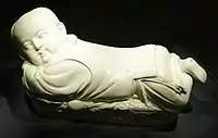 White-glazed pillow in the shape of an infant boy; ding ware, Northern Song Dynasty (960–1127)