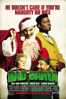 A scruffy dishevelled Santa Claus, standing beside a scowling man in a yellow suit, and a fat child and an Santa helper elf standing in front of them.