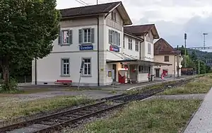 Single railway track, asphalt platform, and two-story station building