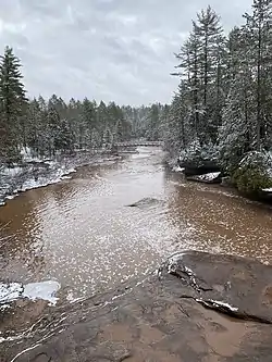 Trail bridge crossing the Baltimore River at O Kun de Kun Falls in Michigan