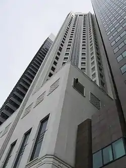 Ground-level view of a 40-storey white building with a square podium and star-shaped cross section