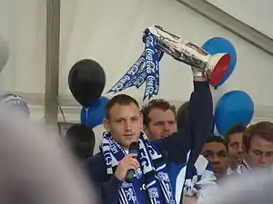 Gillingham captain Barry Fuller displays the trophy during the team's celebratory parade