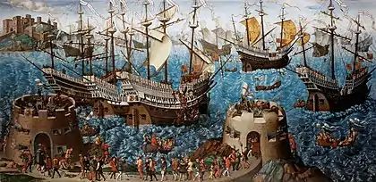 A small fleet of large, highly decorated carracks are riding on a wavy sea. In the foreground are two low, fortified towers bristling with cannon and armed soldiers and retinue walking between them.