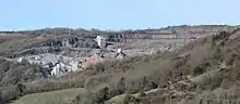 Exposed stone face of quarry, and buildings