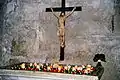 A crucifix in a church, with votive candles.