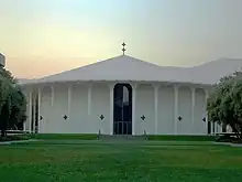 Photo of a  circular building surrounded by grass.