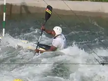 "A male canoeist paddles upstream in a canoe"