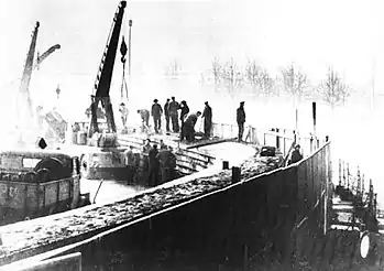 Black and white photo of construction workers, cranes and other equipement erecting the Berlin Wall