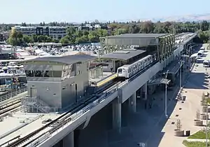 An aerial view of a large metro station with an elevated center platform