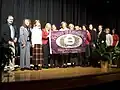 Staff members accept a School of Excellence banner from the School Board.