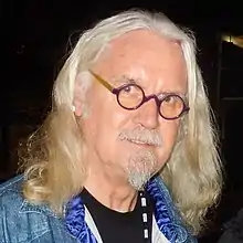 A man with shoulder=length light-coloured hair, beard and moustache