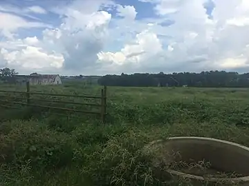 View of cylinder with a barn and a house beyond