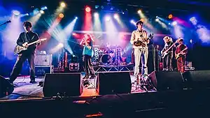 The band performing on a stage