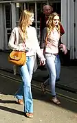 Image 135Two women wearing flared trousers, jeggings and oversized cardigans (from 2010s in fashion)