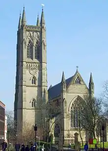 A Gothic Revival church showing its tower on the left, and the east end on the right