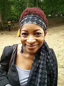 Bonnie smiling to the camera, against a woodland background