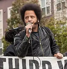 Riley holding a banner and microphone