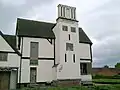 The hunting lodge from the west. The stucco that covered the original patchwork of brick and daub has false windows painted on, a common practice at the time to avoid paying window tax.