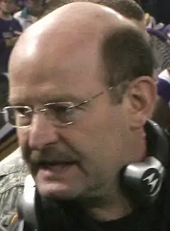 Head shot of bald white man (Brad Childress) with headset