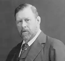 Black-and-white photo of a portly bearded man in a suit