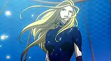 Anime of the upper bust of a young blond woman. She is wearing a body suit and gloves. Her hair is long and seems to be moving to the left.