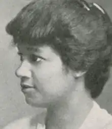 A yearbook photograph of a young African-American woman. Her hair is dressed in an updo with combs at the crown.