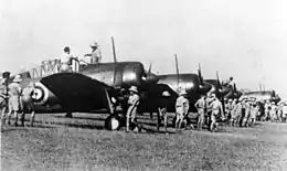 Row of single-engined military monoplanes parked on an airfield