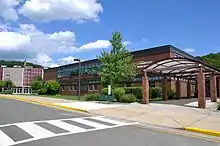 High school building with a two-story rectangular brick building in the foreground and a round auditorium in the background