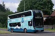 A double-decker bus in Brighton & Hove's teal and aqua 'Live & Breathe' livery in Falmer