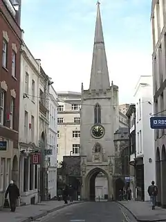 Broad Street, Bristol. A narrow street of historic buildings, spanned by an archway on which stands the tower of St John-on-the-Wall.