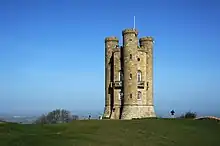 Golden limestone tower with three circular turrets that run the height of the building.