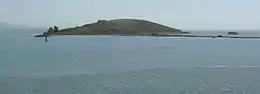 A gray, dome-shaped island rises out of the water.