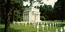 White building behind rows of identical white gravestones