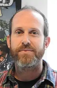 A man with short brown hair, smirking at the camera.