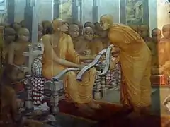 monk giving texts to a more senior monk